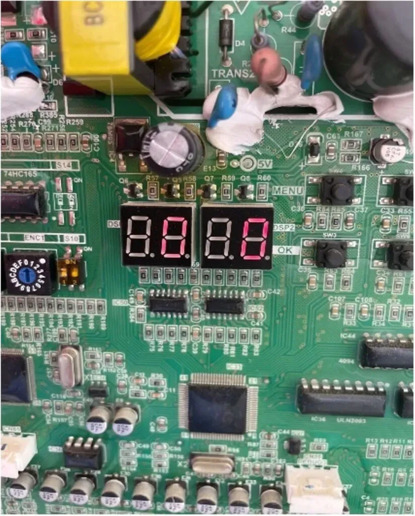 Close-up of a green electronic circuit board with two red LED displays and various components.