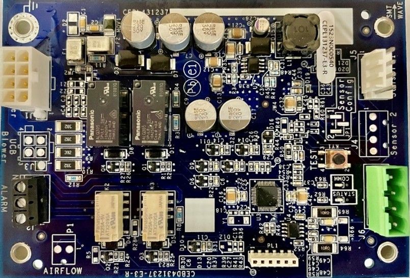 Blue printed circuit board with chips, capacitors, connectors, and a green terminal block on the right.