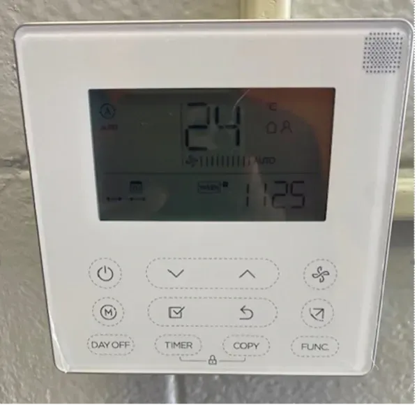 White wall thermostat control panel showing 24°C with buttons and display icons
