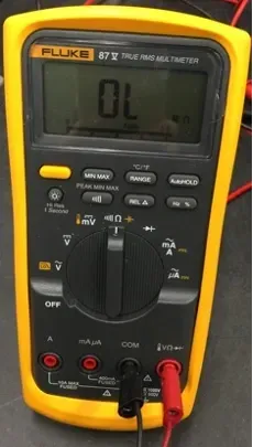 Fluke digital multimeter showing “OL,” with red and black probes plugged in at the bottom.