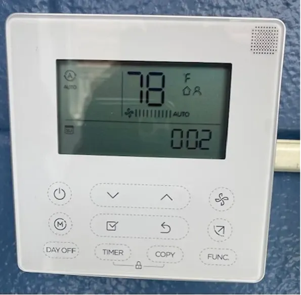White wall-mounted digital thermostat showing 78°F and fan setting, with buttons below the display