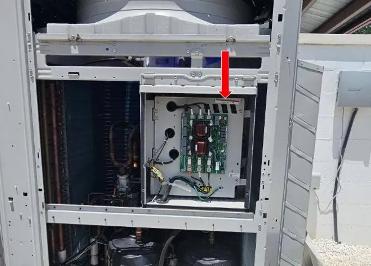 Open electrical cabinet with circuit board, highlighted by a red arrow on the right side.