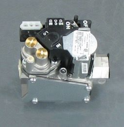 Compact black and silver mechanical device with switches, brass fittings, and a metal housing on a gray surface