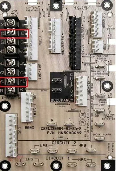 Close-up of a circuit board with labeled connectors and terminal blocks, with red rectangles highlighting two areas