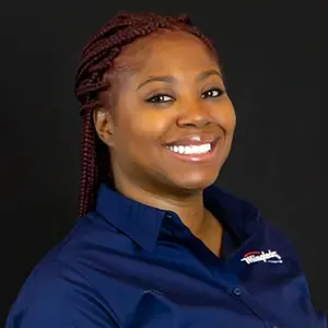 Smiling woman in a navy shirt against a black background