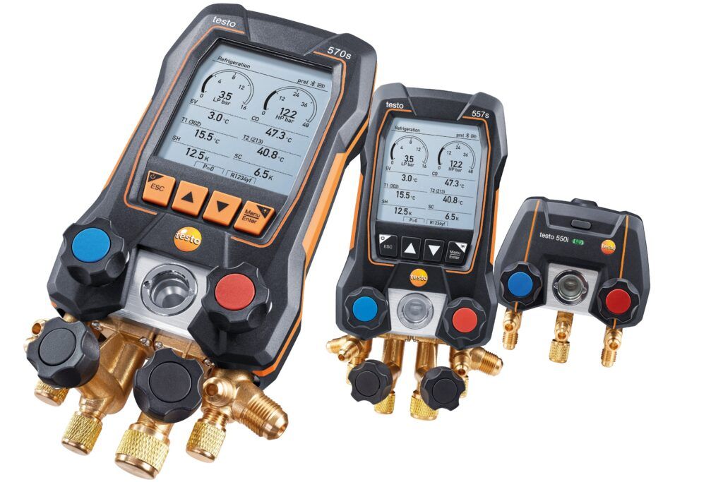 Three digital manifold gauge meters with colored buttons and brass fittings on a white background