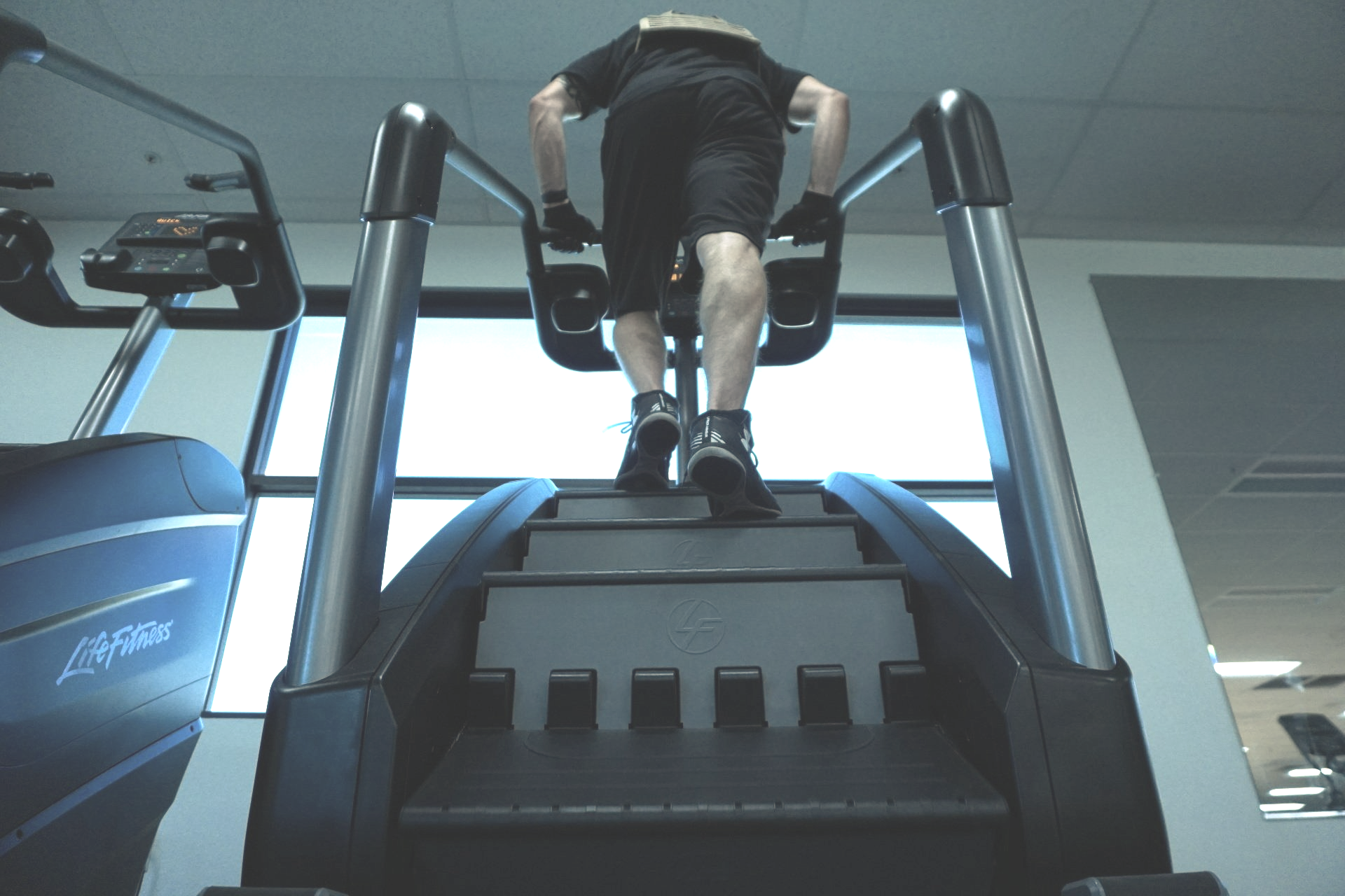 A man is walking up a set of stairs in a gym