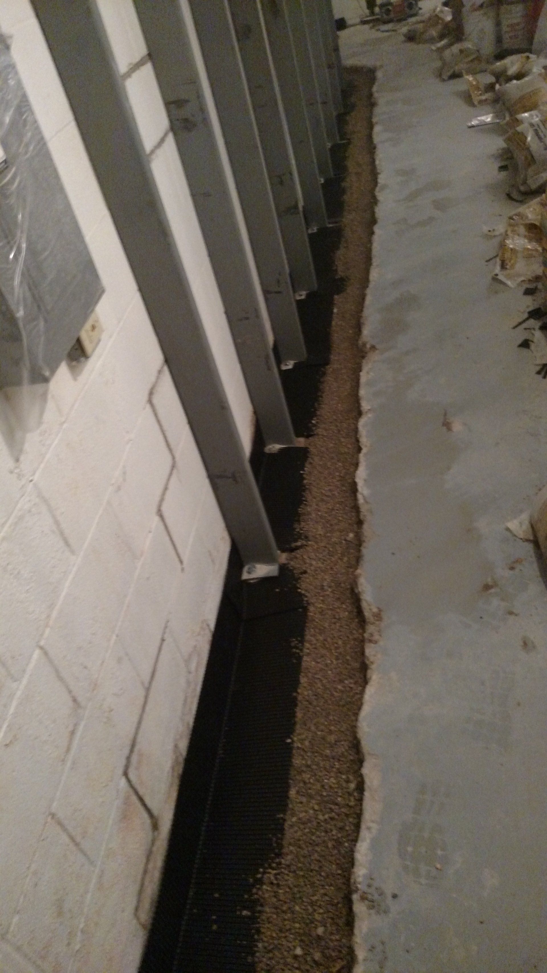 cinder block foundation A drainage system is being installed in a basement.