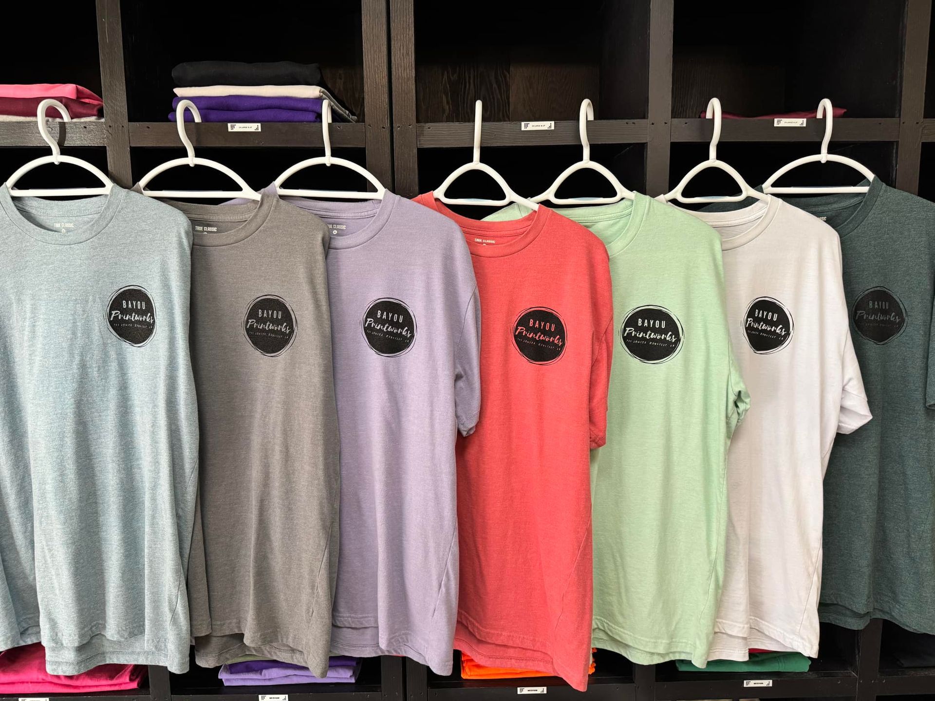A bunch of t-shirts are hanging on a rack