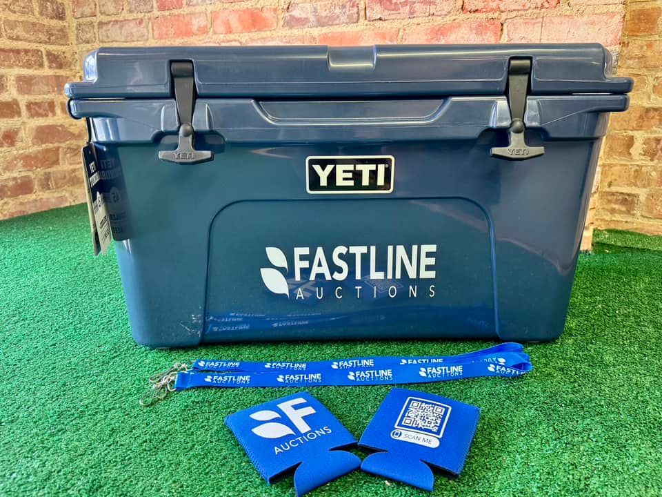 A yeti cooler is sitting on top of a lush green field.