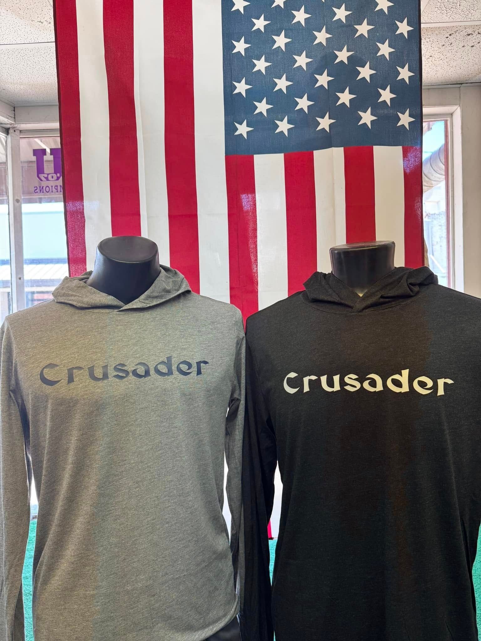 Two crusader hoodies are displayed in front of an american flag