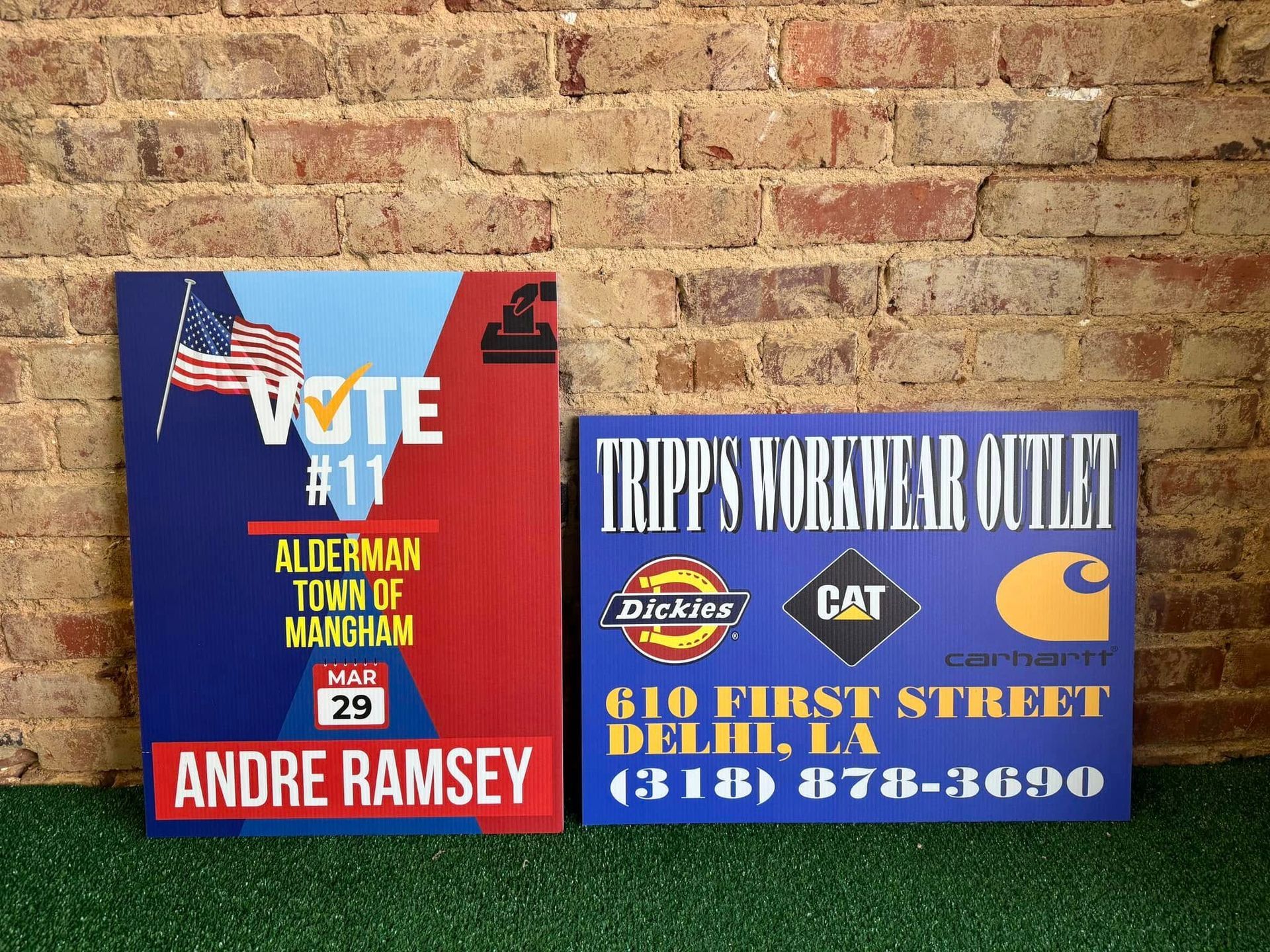 A sign for andre ramsey is next to a sign for tripp 's workwear outlet