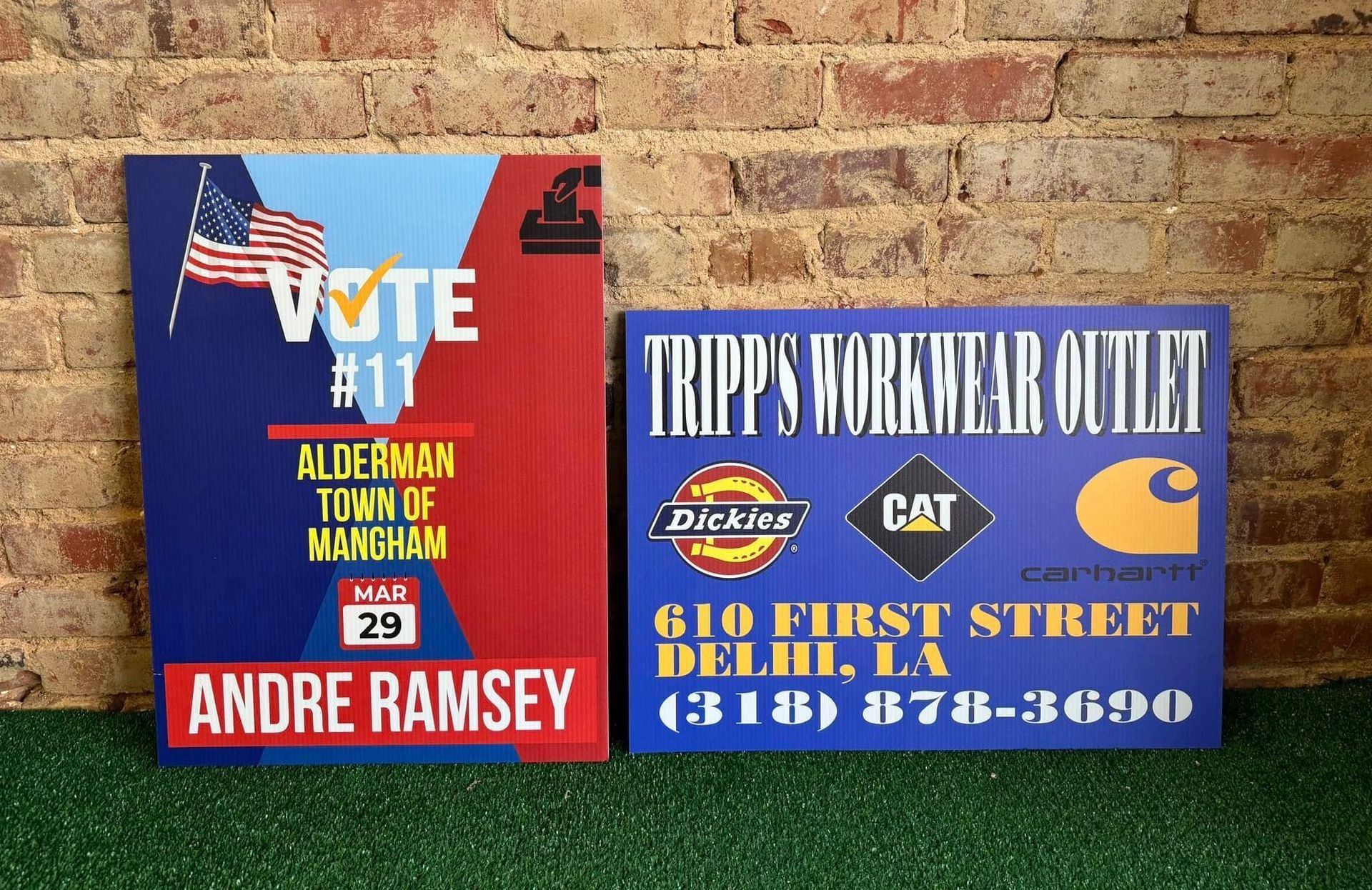 A sign for andre ramsey is next to a sign for tripp 's workwear outlet