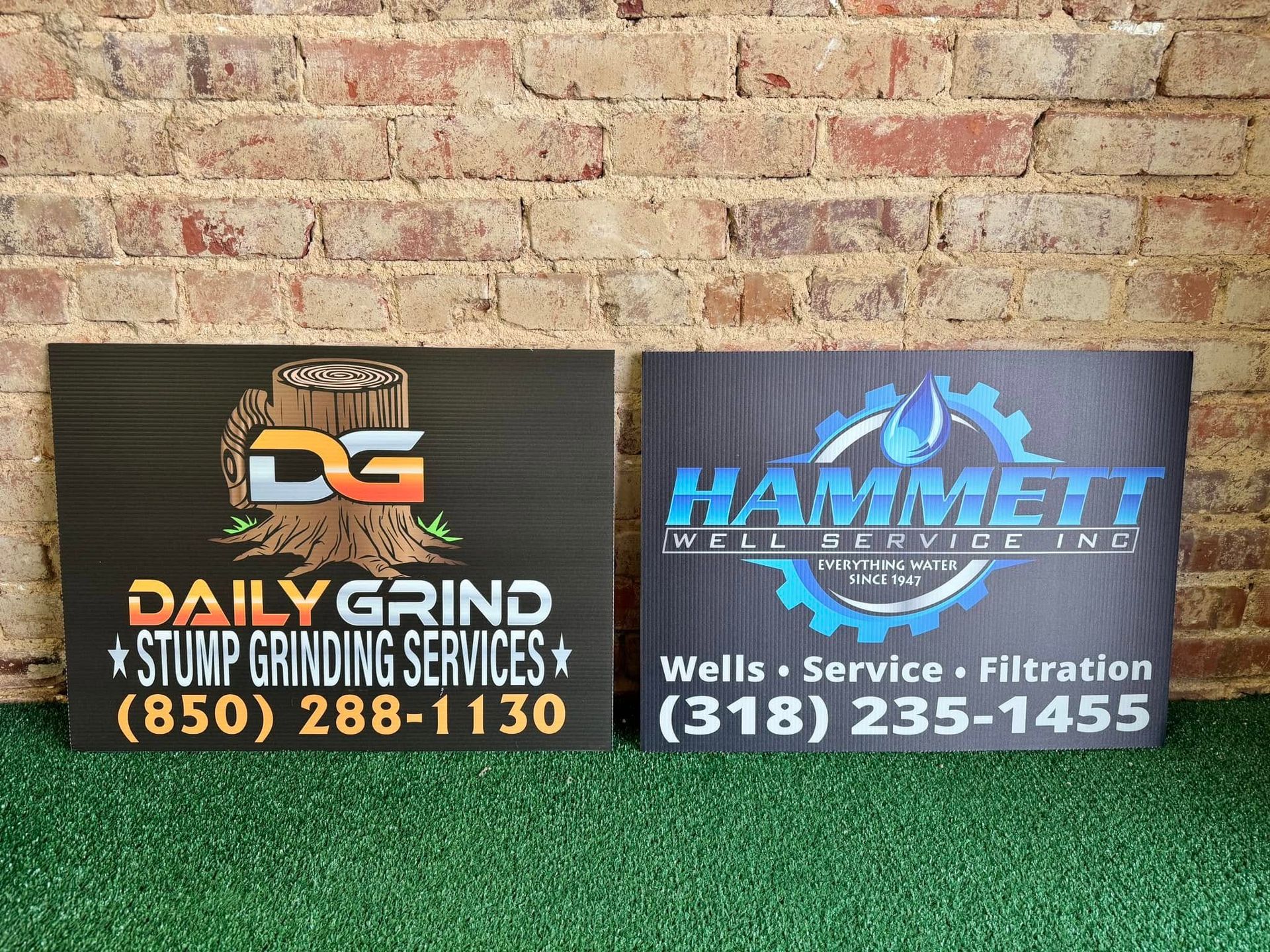 Two signs are sitting next to each other in front of a brick wall.