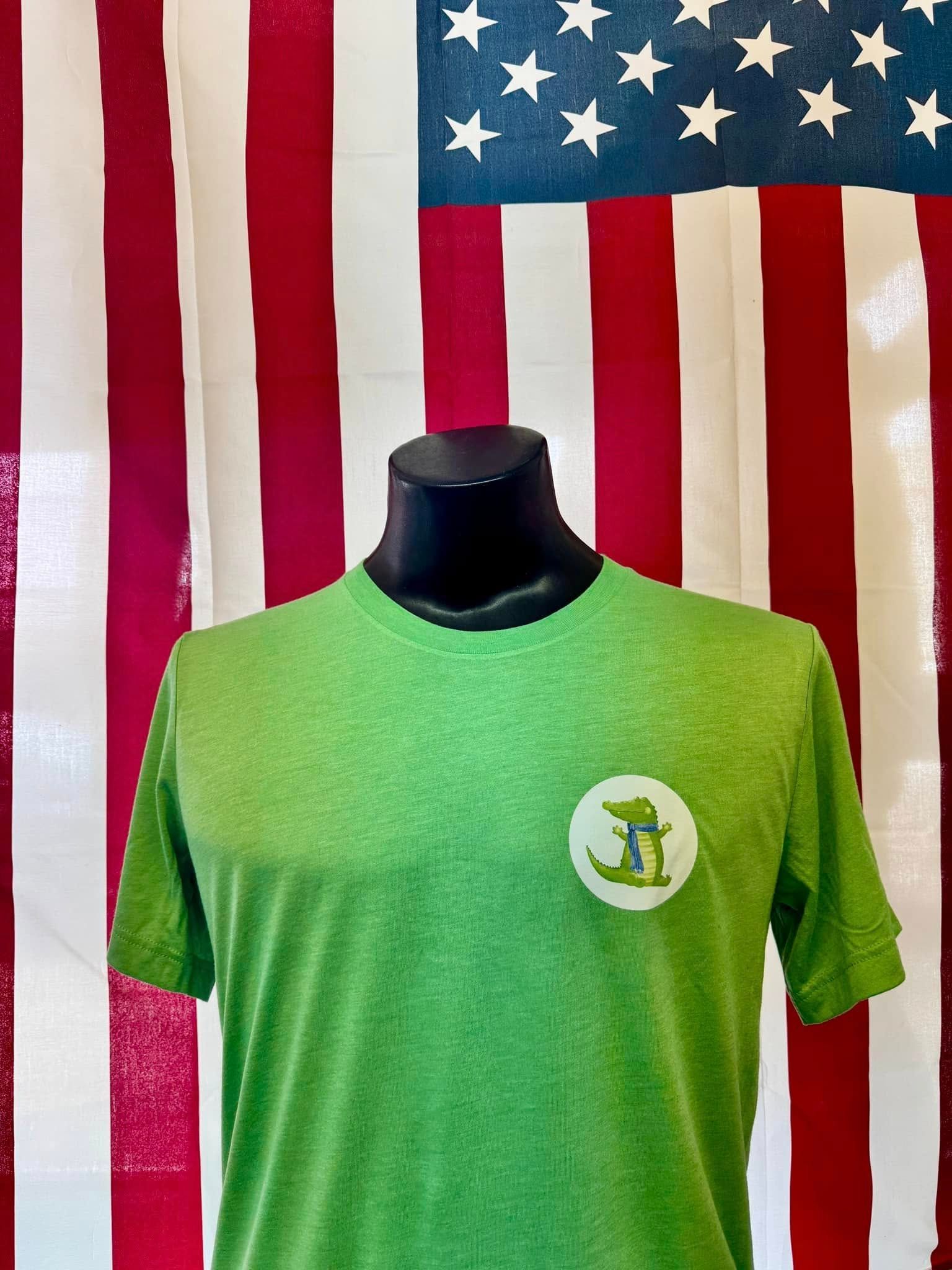 A green t-shirt is on a mannequin in front of an american flag.