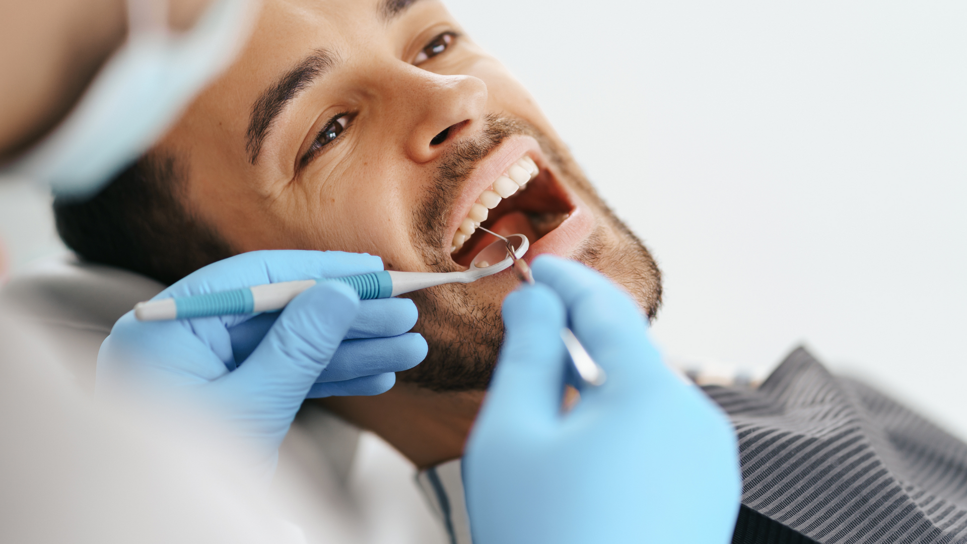 a man is getting his teeth examined by a dentist .