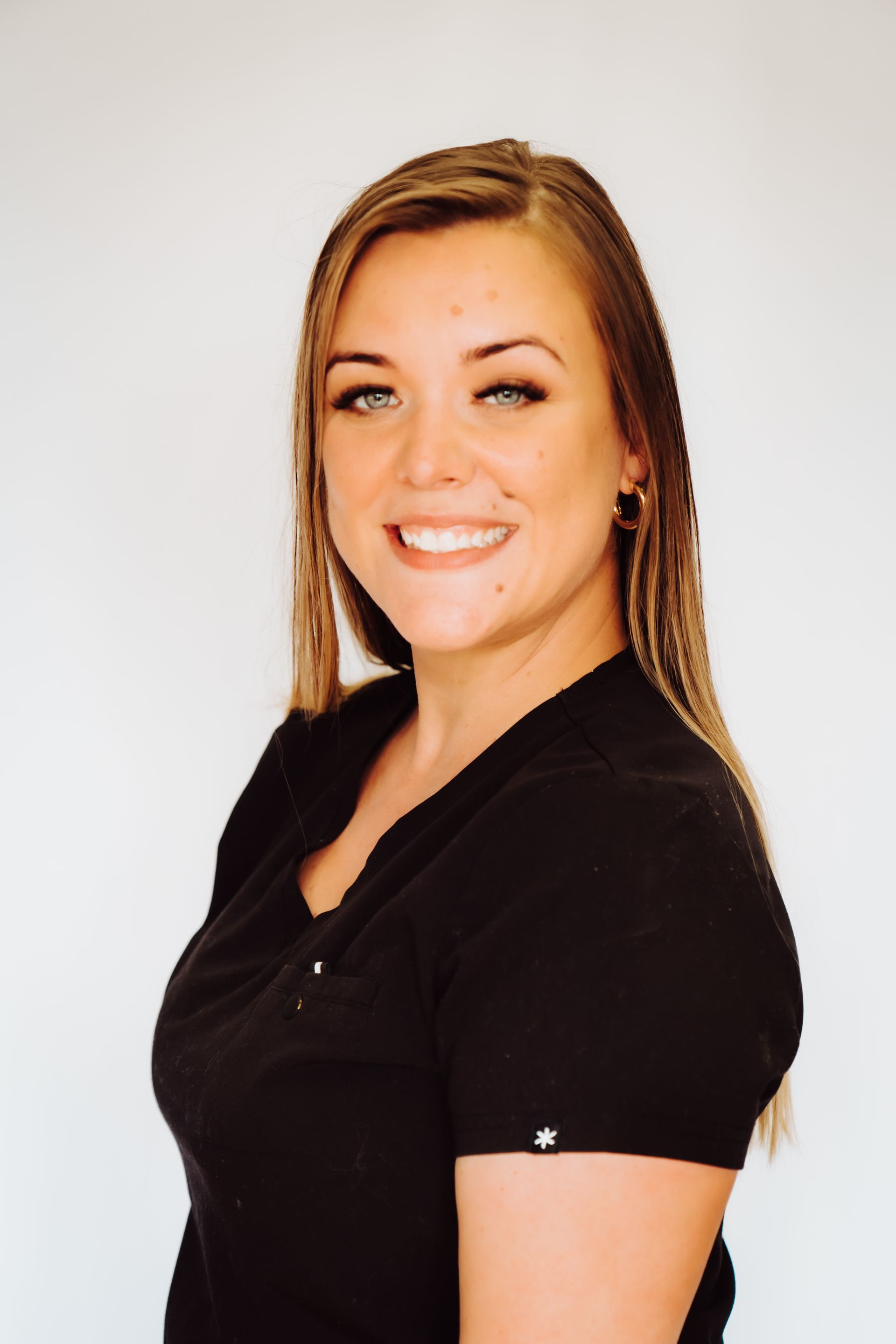 a woman in a black shirt is smiling for the camera .