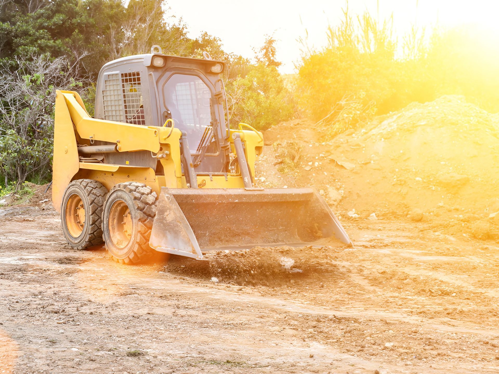Yellow Skid Steer Loader Operating on Dirt — Compass Equipment Hire in Pottsville, NSW