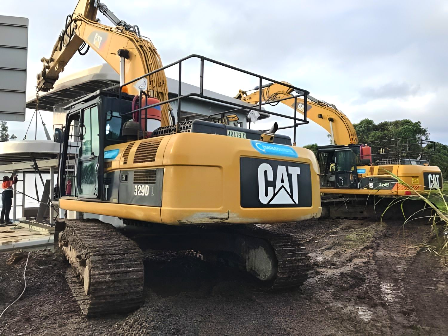 Two Yellow CAT Excavators Lift a Large Concrete Structure — Compass Equipment Hire in the Northern Rivers, NSW