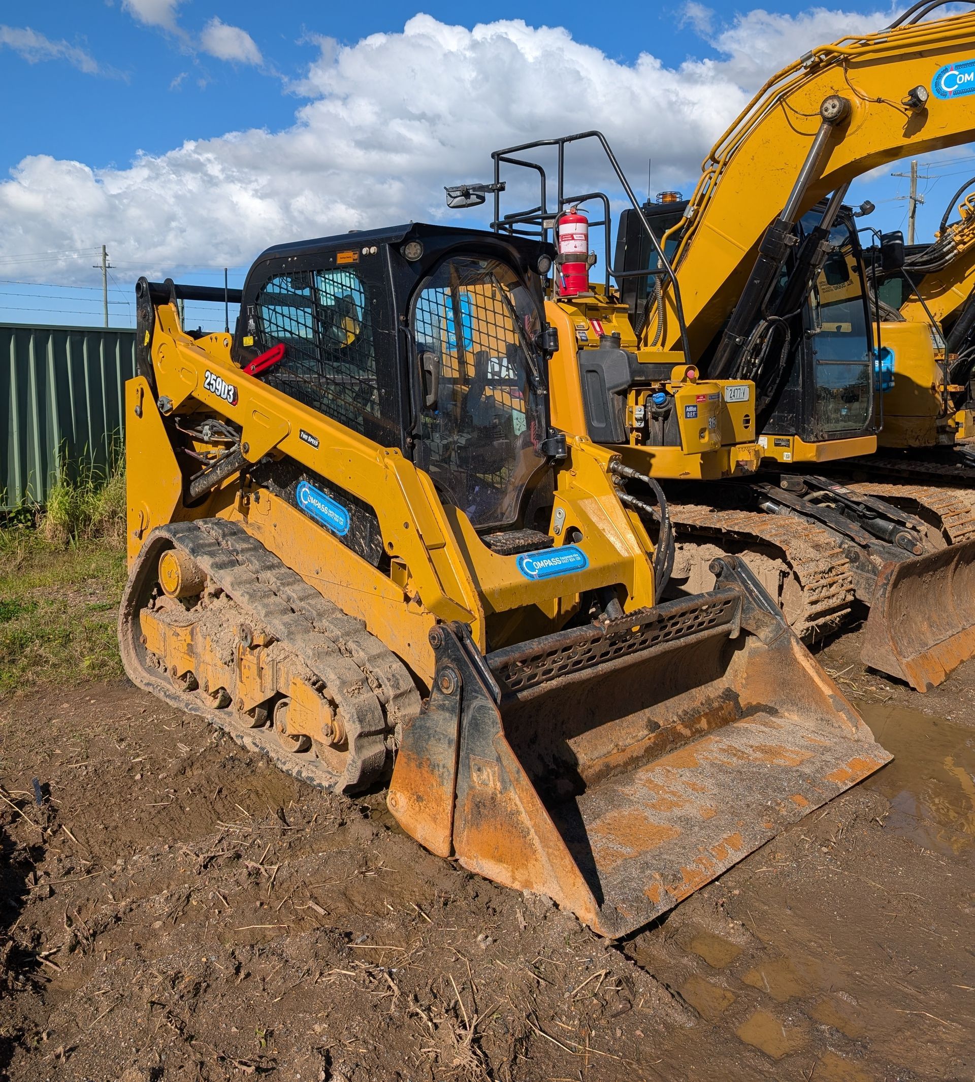 Yellow excavator and skid steer on a muddy construction site under a blue sky — Compass Equipment Hire in the Northern Rivers, NSW