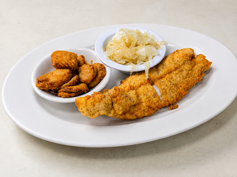 Fried fish fillet with potato wedges and coleslaw on a white plate