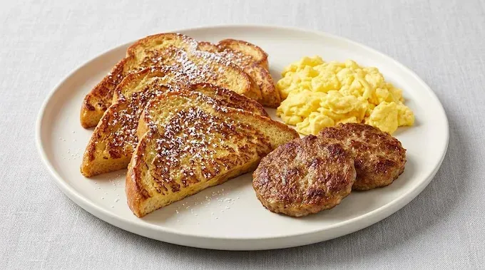 Plate with French toast, scrambled eggs, and sausage patties on a white dish