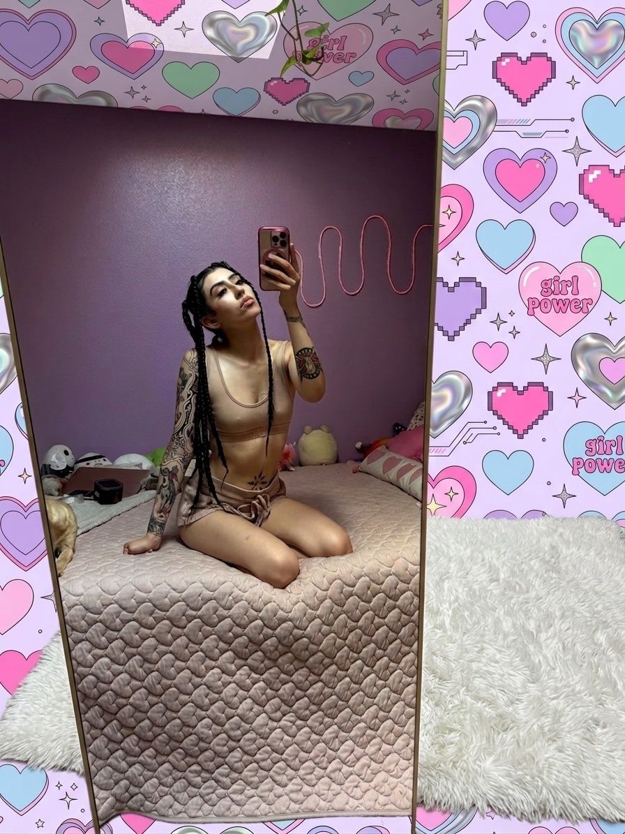 Woman taking a mirror selfie in blue lingerie, pouting, with long dark hair.