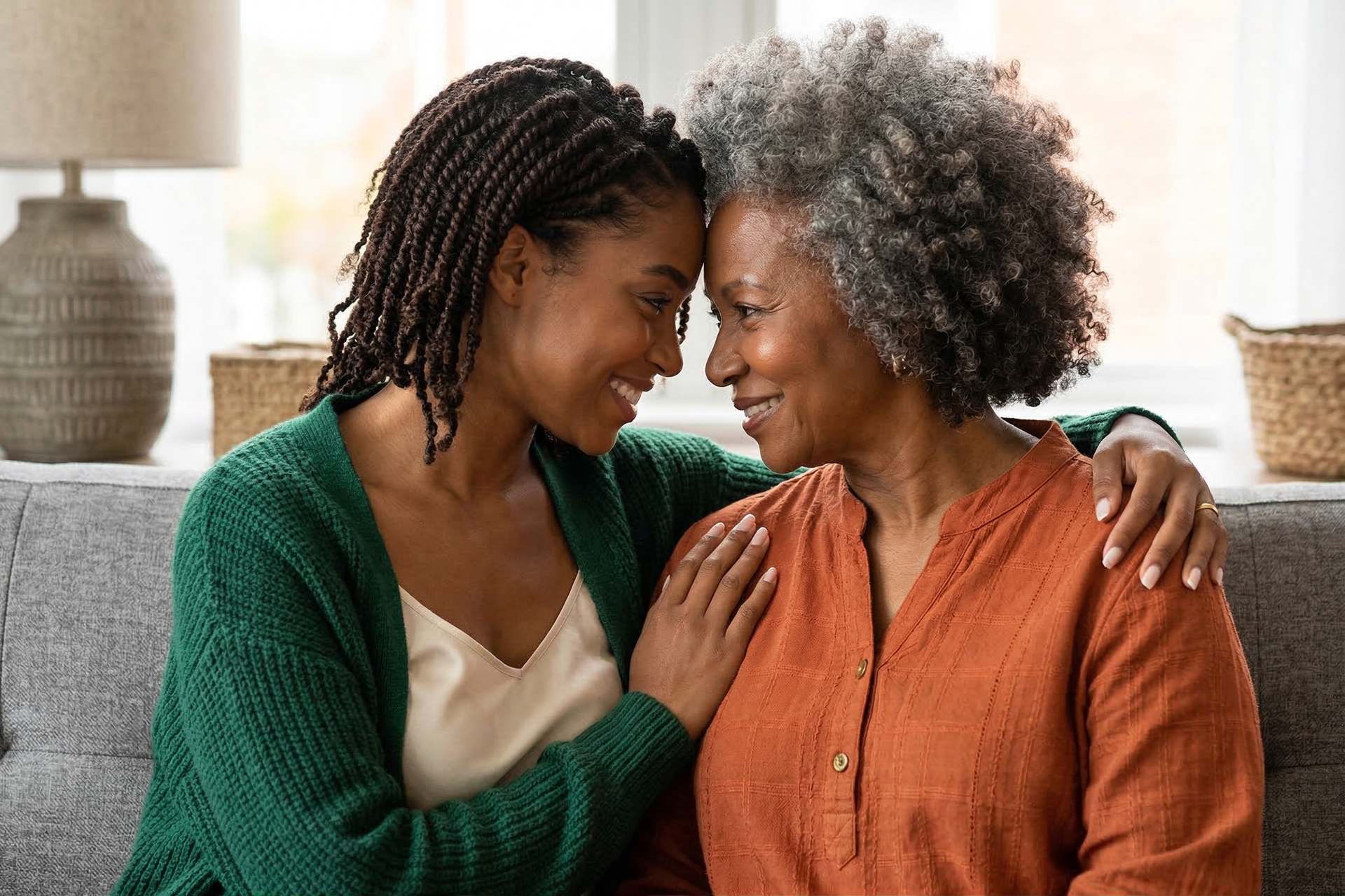 Two people smiling and leaning close on a couch in a cozy living room