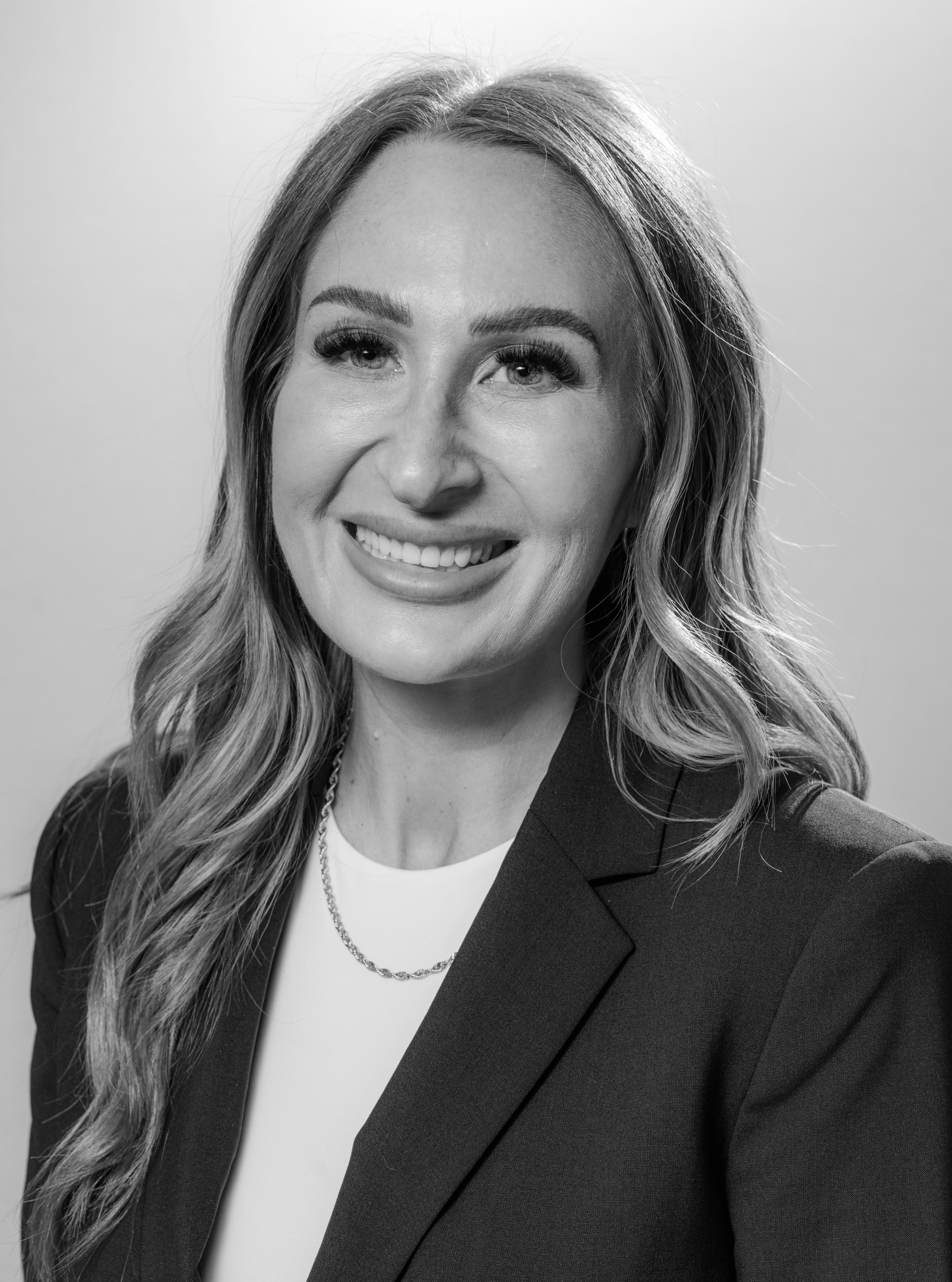 A woman in a black shirt is smiling for the camera.