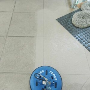 Tile floor being cleaned by a blue Hydro Force machine; partially cleaned area shown.