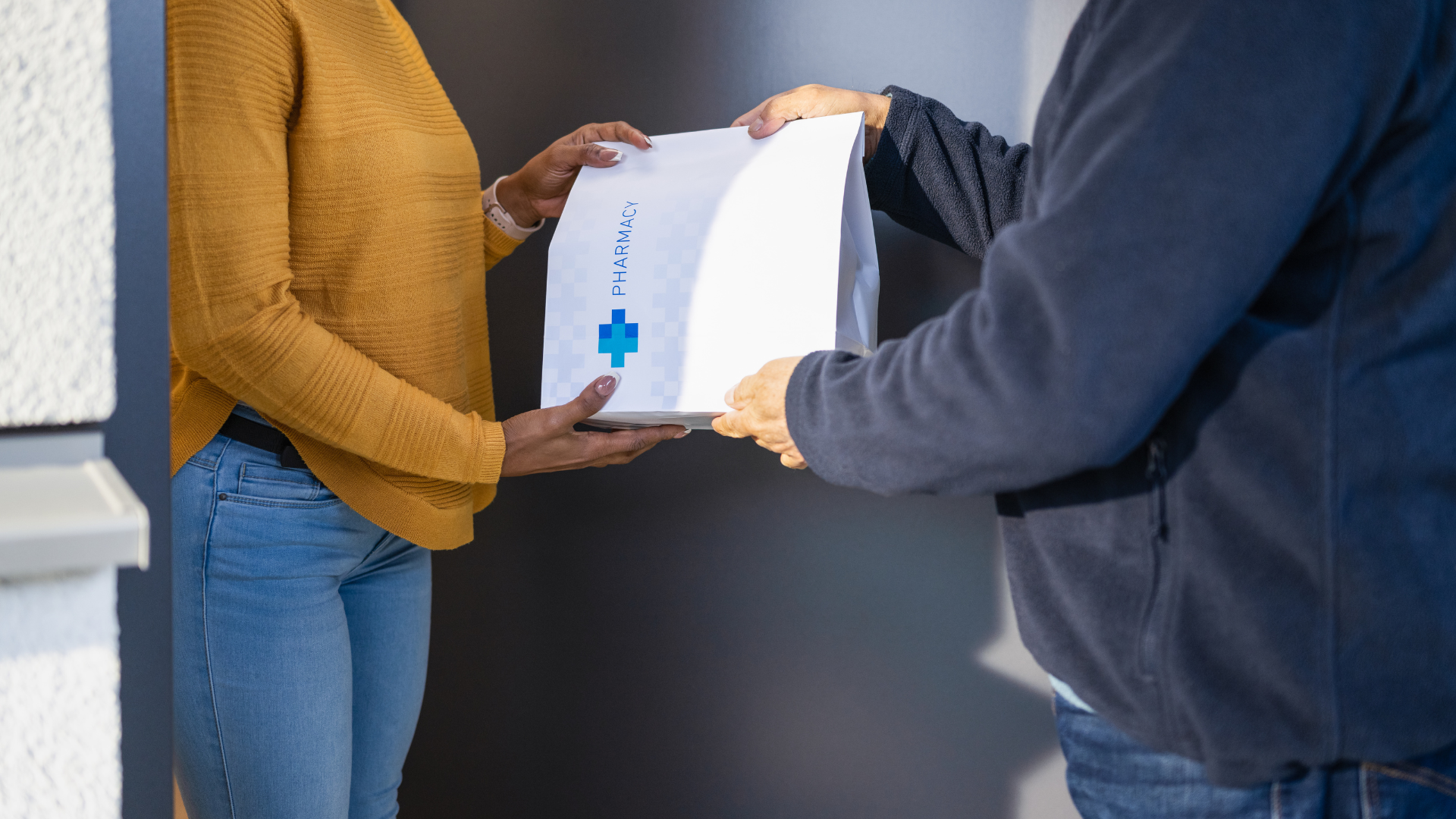 A man is handing a package to a woman.
