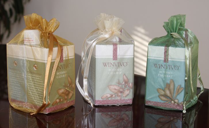 Three wrapped gift sets, each in a box and tied with decorative ribbon.