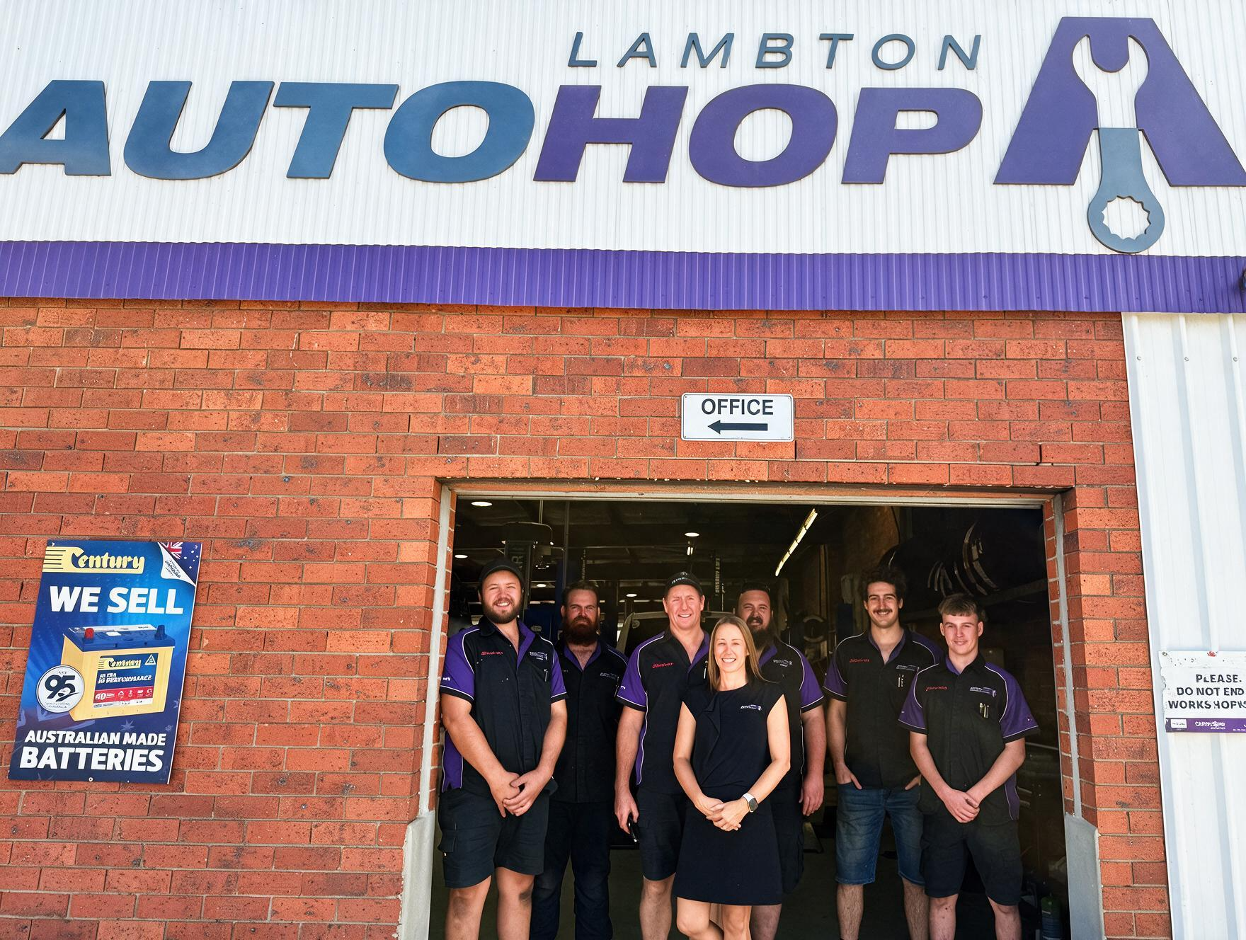 Lambton AutoHop storefront with five staff standing in the doorway under a blue-and-white sign