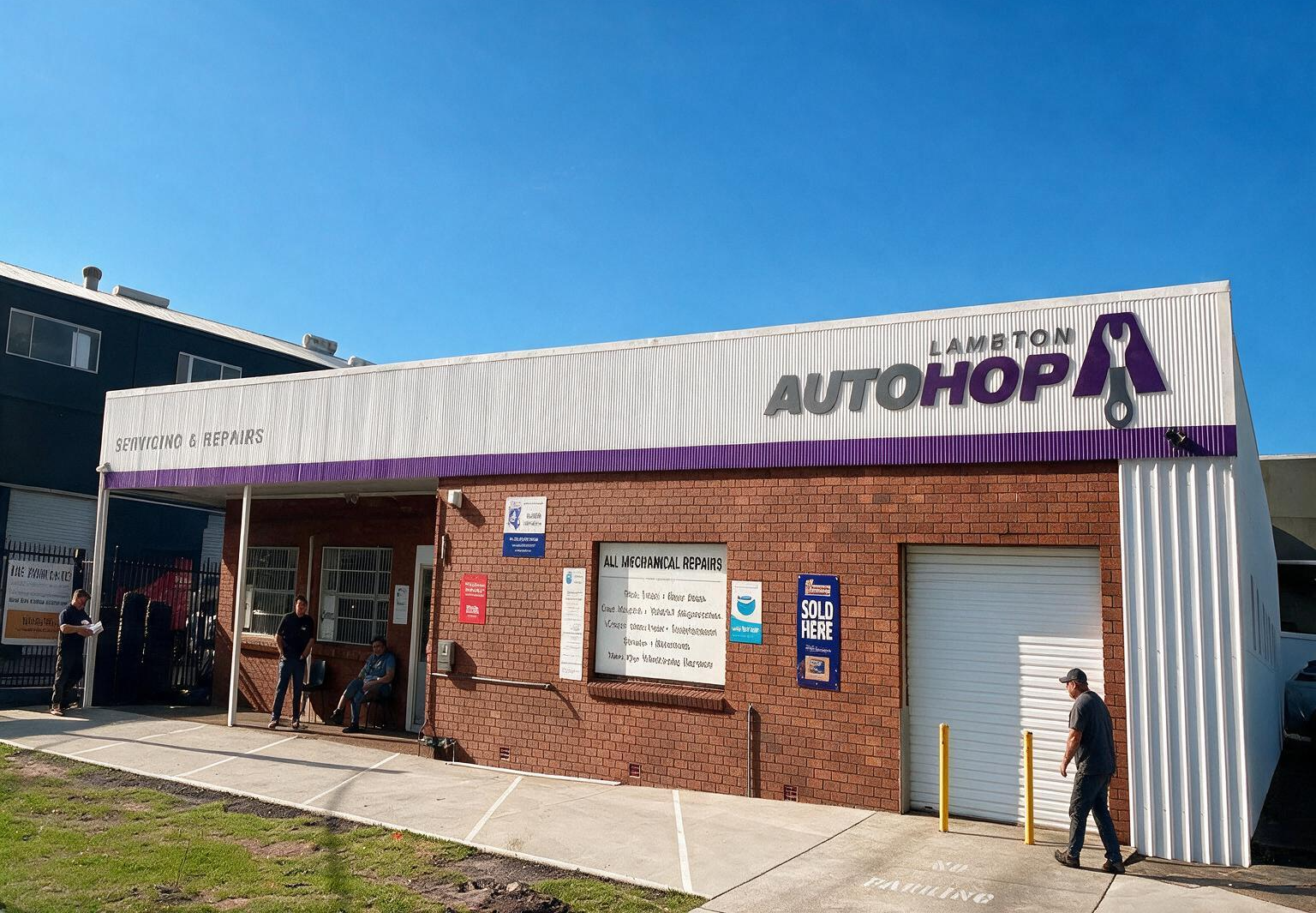 Small brick storefront with a purple sign and people standing outside on a sunny day