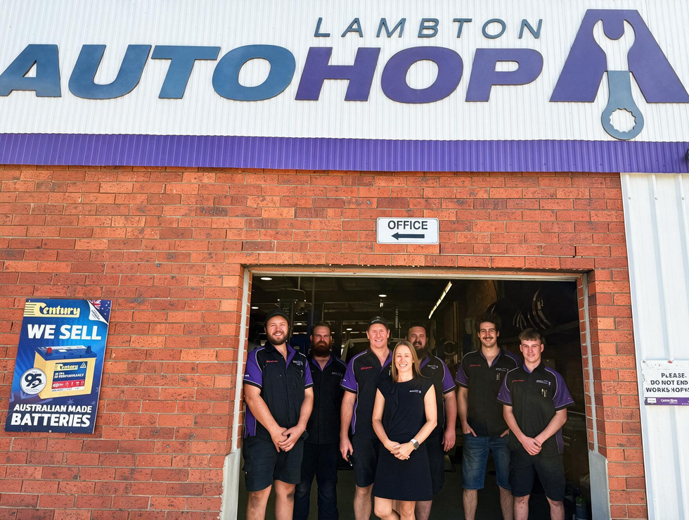 Staff standing at the entrance of Lambton Autohop auto shop under a blue-and-white sign