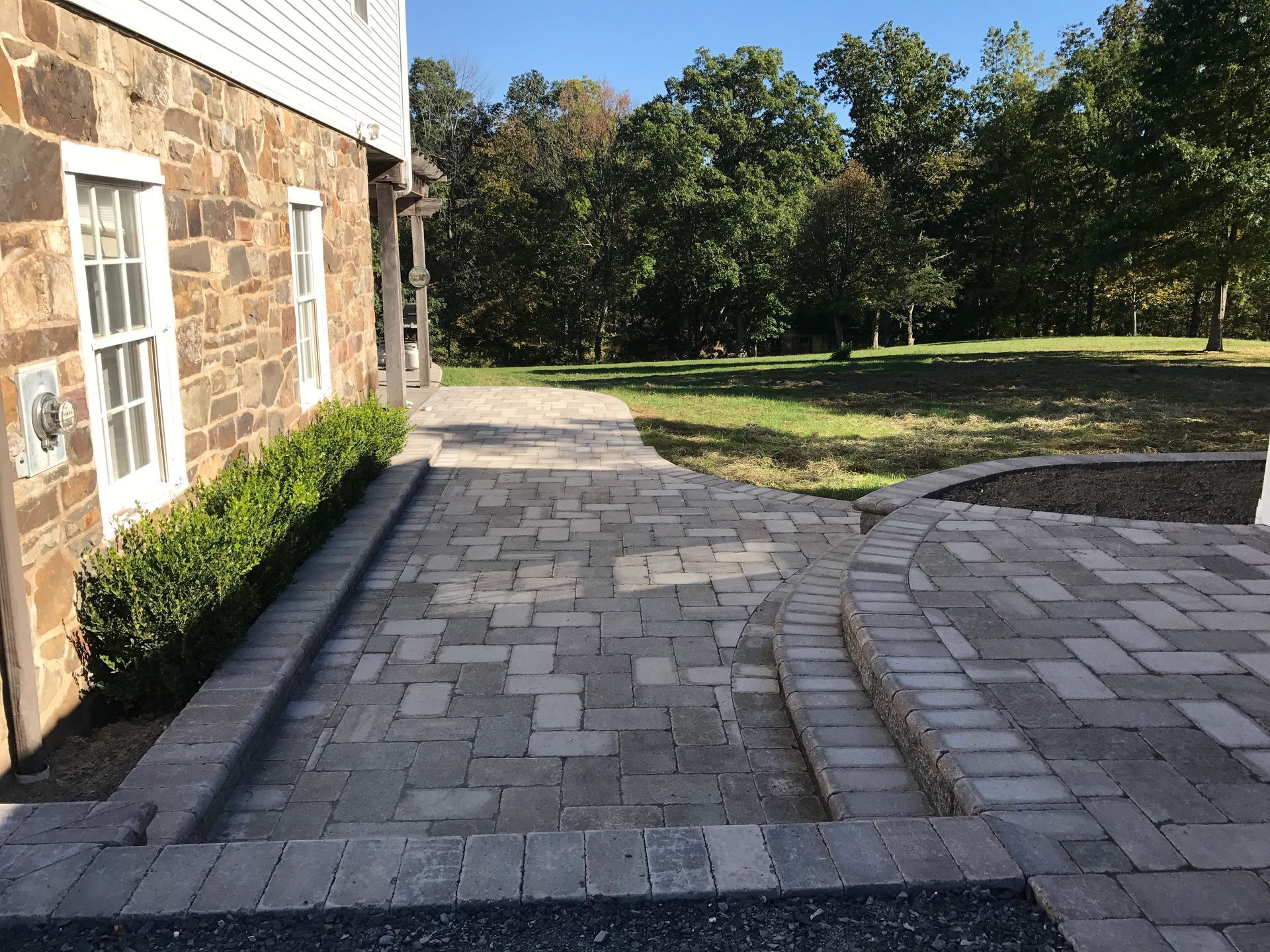 A stone house with a brick walkway leading to it