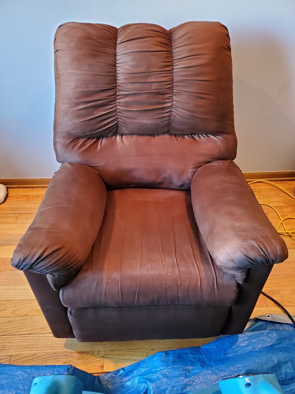 Brown recliner chair on a wooden floor.