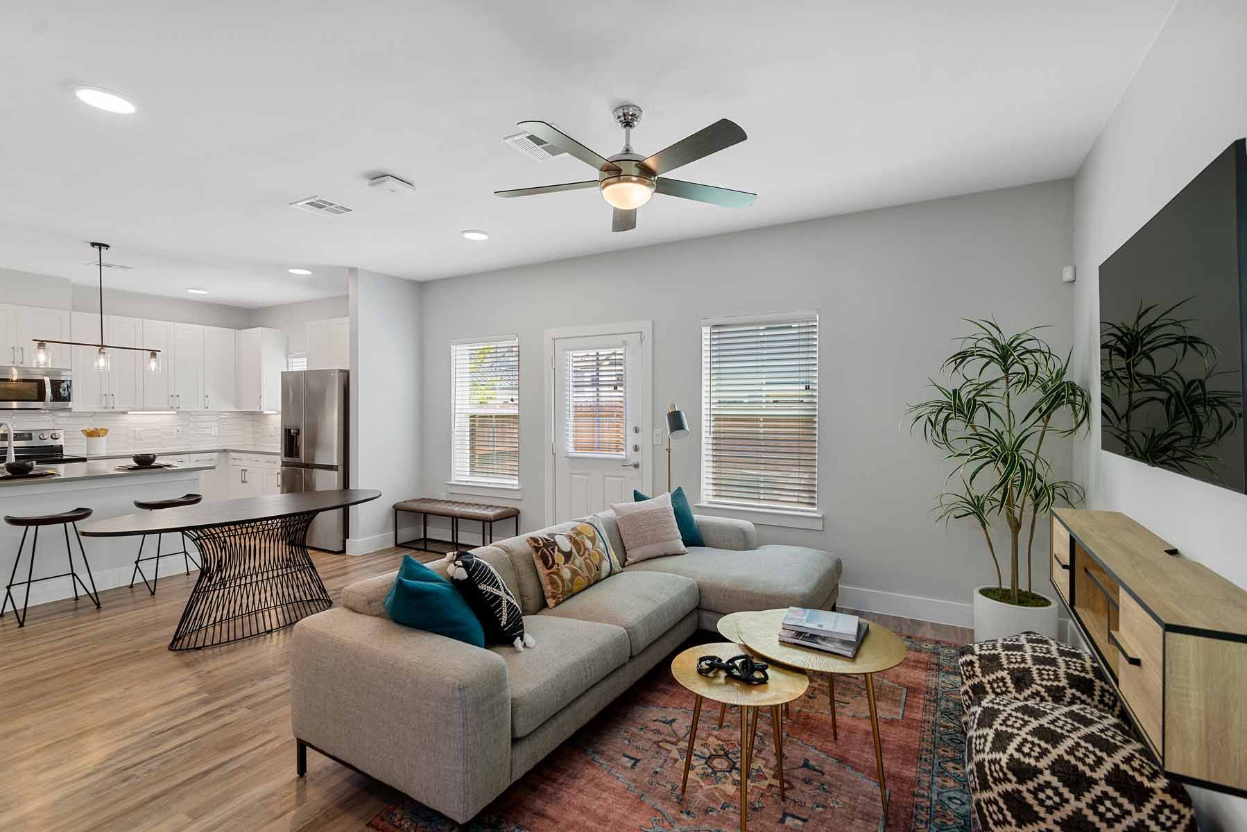 Luxury Apartments in Spring, TX - Villas at Birnham Woods - A Living Room with Large Sectional Sofa and Two Round Gold-Toned Coffee Tables.