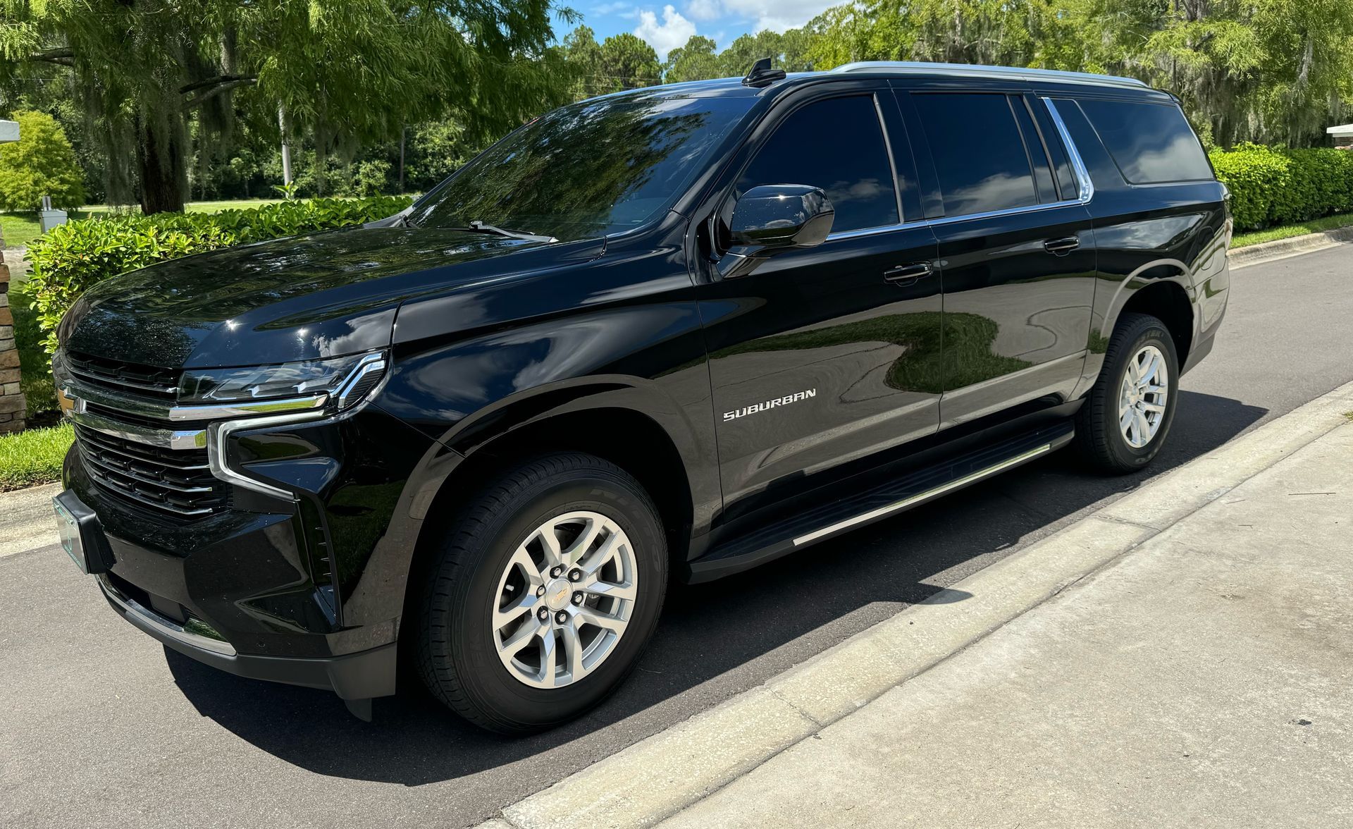 Black Chevy Tahoe SUV parked on a sunny street.