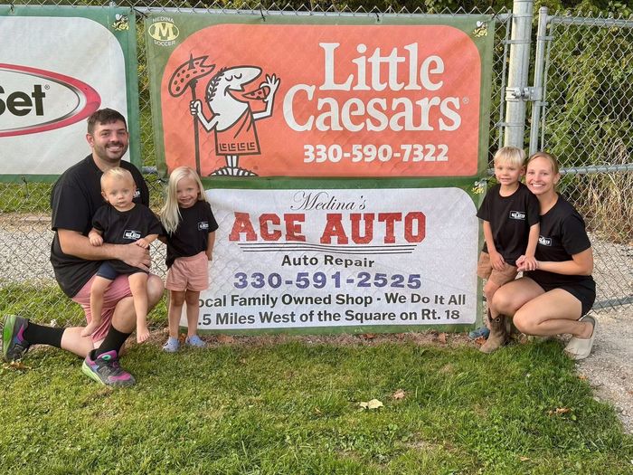 Small rural auto repair shop with red garage doors and a sign reading “Auto Parts” on a cloudy day | Medina’s Ace Auto