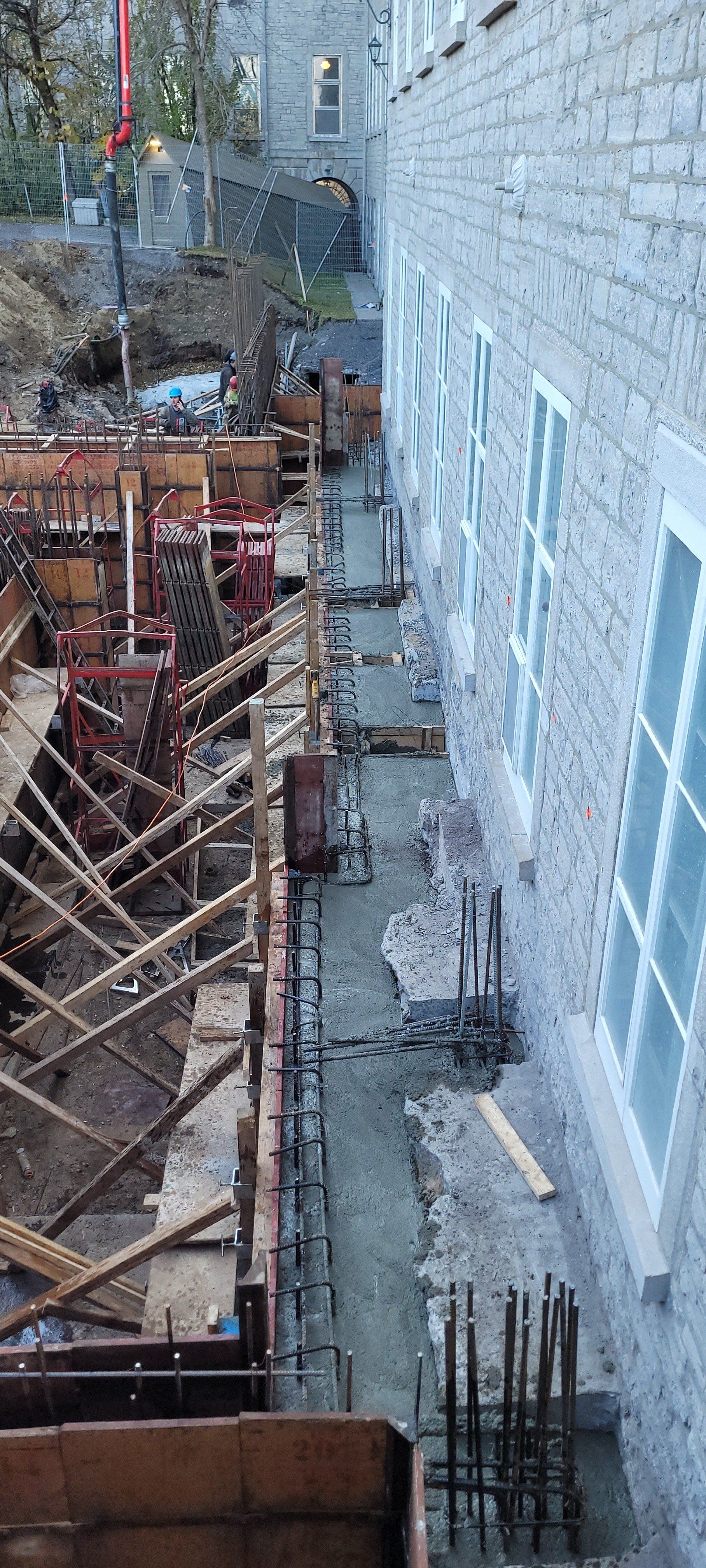 Un chantier de construction avec un bâtiment en brique en arrière-plan.