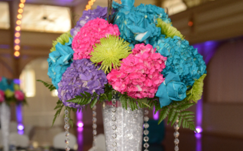 Colorful flower bouquet in a silver vase with blue, pink, green, and purple blooms