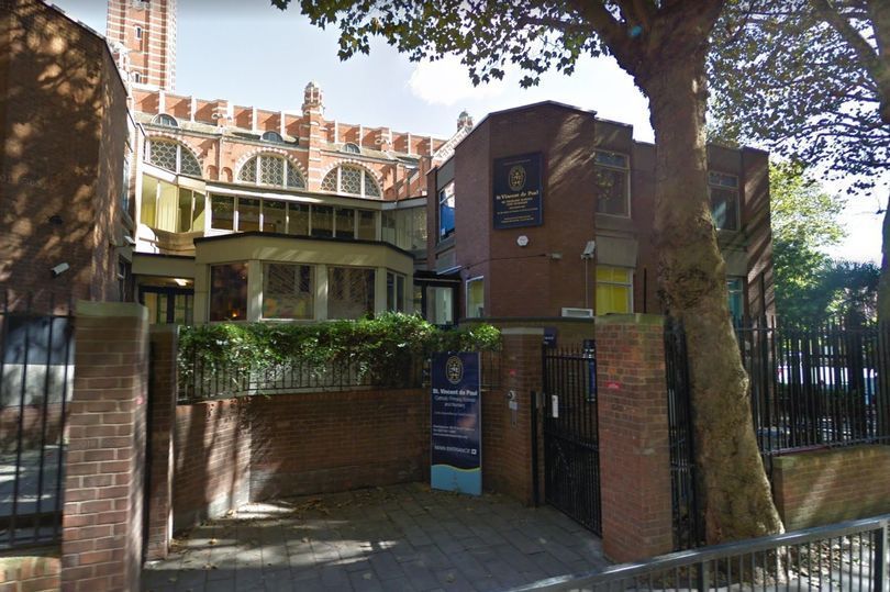 a large brick building with a tree in front of it .