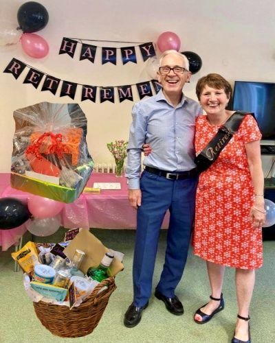 A man and woman are posing for a picture at a retirement party.