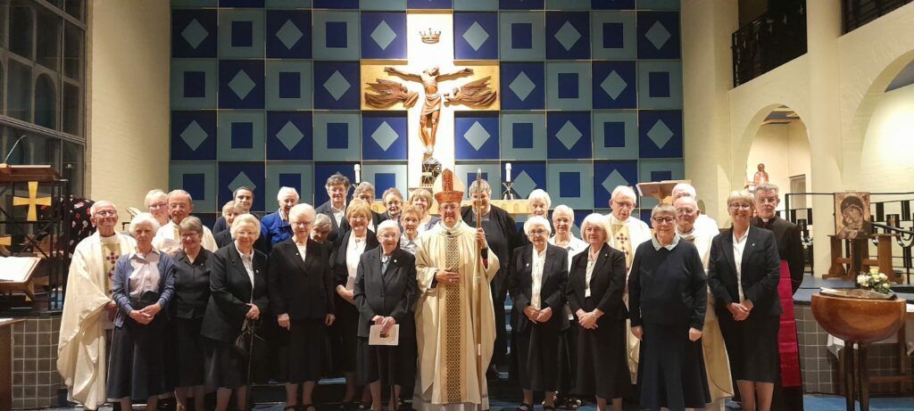 A group of people standing in front of a cross in a church