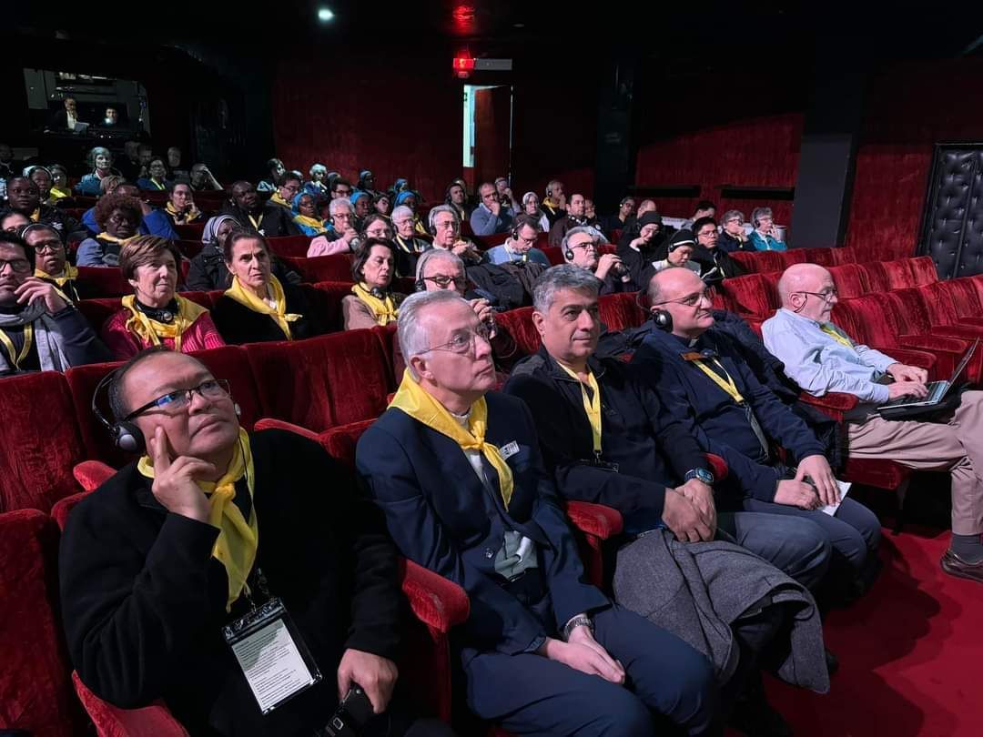A group of people are sitting in a theater watching a movie.