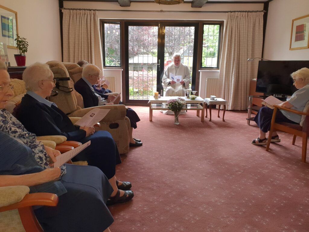 A group of elderly people are sitting in a living room
