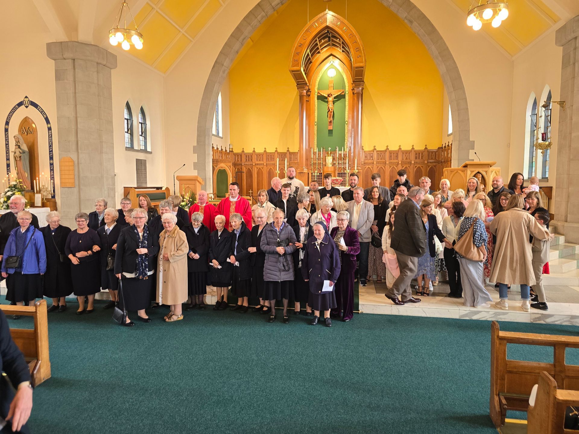 A large group of people are standing in a church.