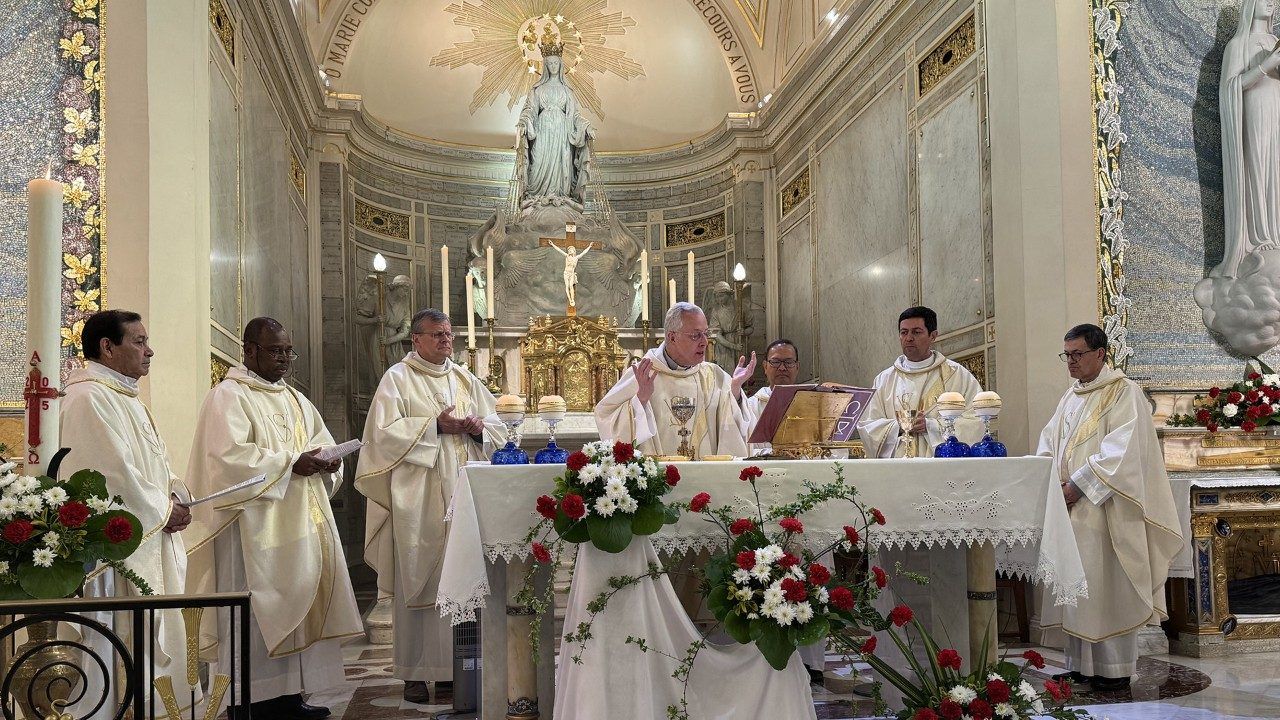 Clergy at a church altar, conducting a religious service. White robes, flowers, and ornate setting.