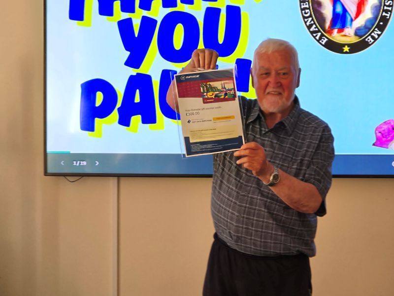 Elderly man holding certificate in front of
